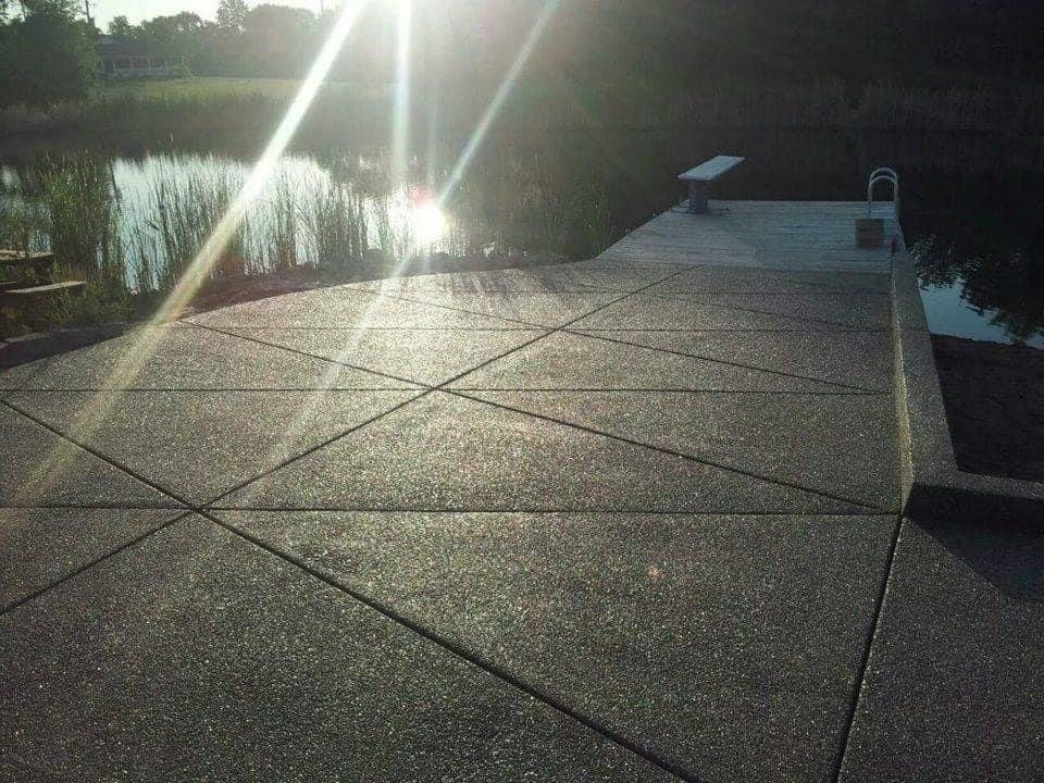 Concrete pool deck surrounding a residential swimming pool