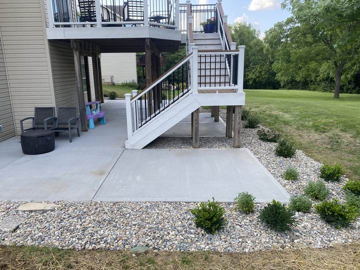 Broom patio under a raised deck with new landscaping in Carmel, Indiana