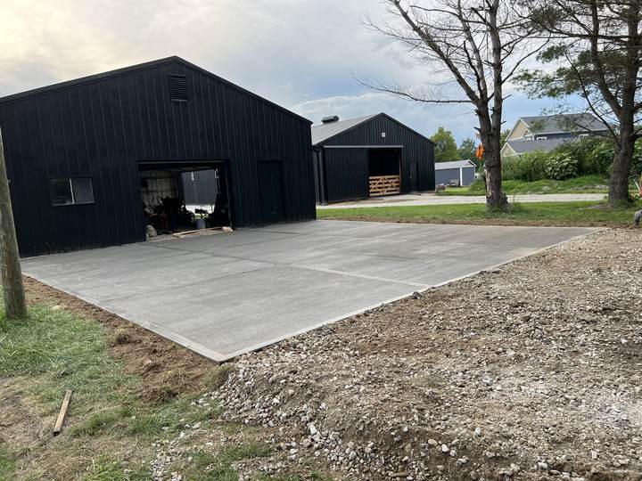 Large concrete apron at a black steel building